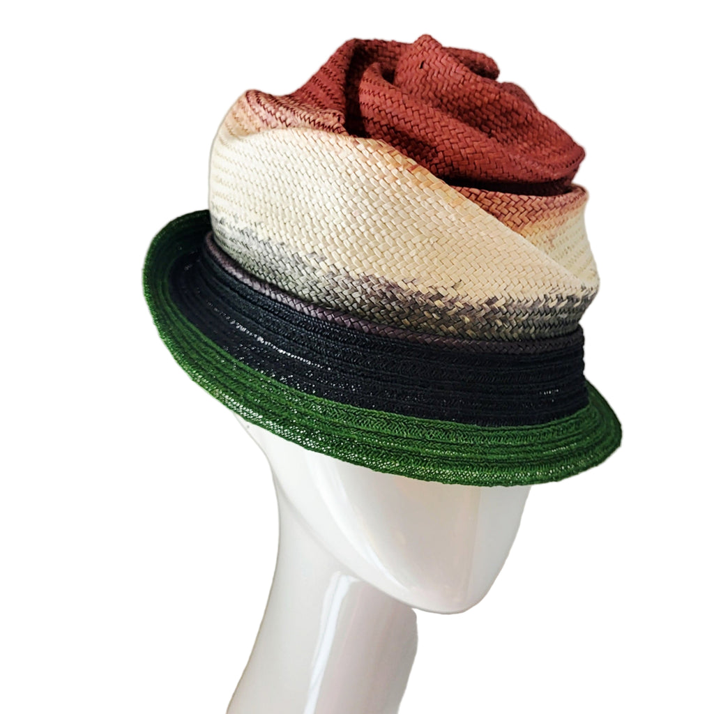 Multicolored straw hat on a mannequin head against a plain background