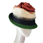 Multicolored straw hat on a mannequin head against a plain background