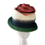 Multicolored straw hat on a mannequin head against a plain background